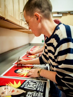 Jana Hunter and other members of Lower Dens sign several posters (drawn by Baltimore artist Alex Fine) before An Evening With Lower Dens at WTMD (Photo by Steve Parke)